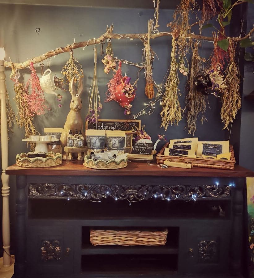 Dried botanicals hanging above a brass hare on the apothecary dresser