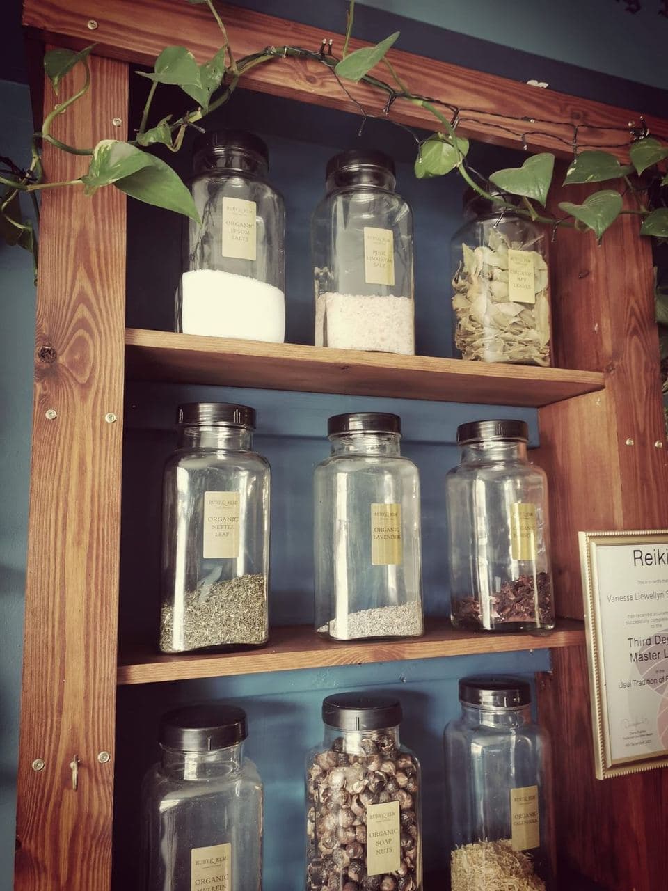 Organic herb and salt jars on wooden shelves in the boutique